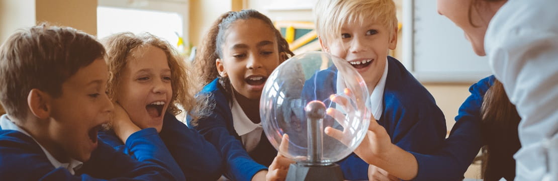 Children participate in a hands-on science lesson with their teacher, highlighting how 529 plan funds can help cover eligible K–12 education expenses.